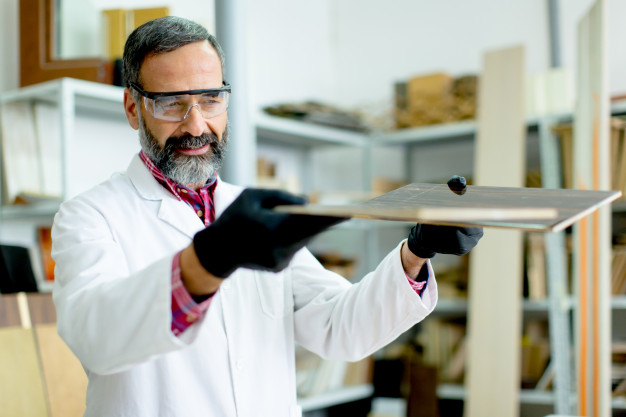 handsome-mature-engineer-testing-colors-wooden-specimens-furniture-factory_52137-1375